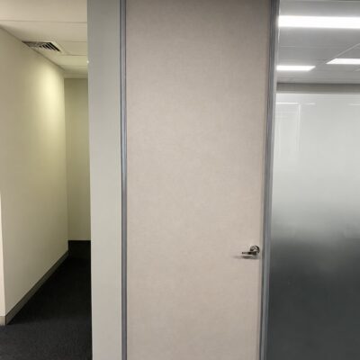Custom made acoustic RW36 office door in a silver frame beside frosted glazing at Alpha National, Perth