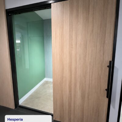 Timber-finish custom acoustic sliding door with black frame and 10.5mm VLam Hush secondary glazing at Hesperia, Perth